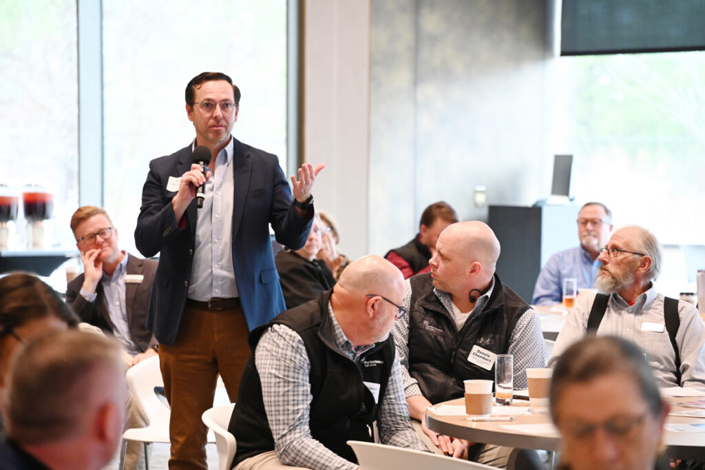 Speakers and attendees have a discussion at a northwest Arkansas meeting.
