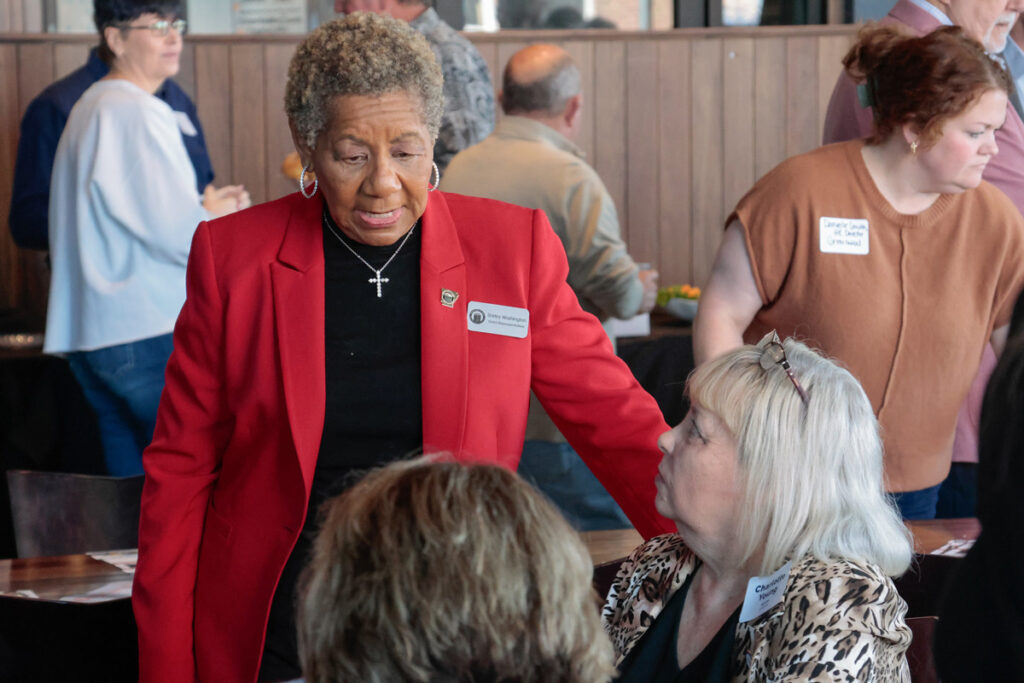 League Field Rep Shirley Washington talks to two attendees.