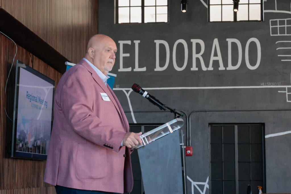 El Dorado Mayor Paul Choate stands at a podium and speaks to attendees at the regional meeting.